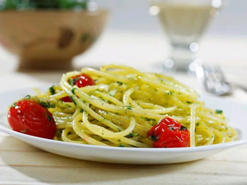 receta Spaghetti sans gluten Barilla® avec tomates raisins frites, pesto d'épinards et persil